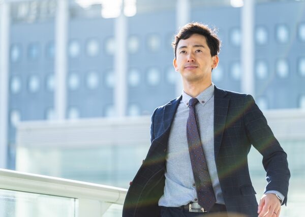 ビジネス街に立つ自信に満ちた男性ビジネスマン