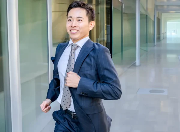 長時間労働に疲弊しながらも前を向いて歩く日本のビジネスパーソン。過労死(Karoshi)の社会問題と働き方改革の必要性を象徴するイメージ。