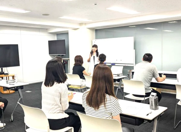 健康経営研修の導入判断と必要性をテーマに講義する講師タニカワ久美子と受講者の様子