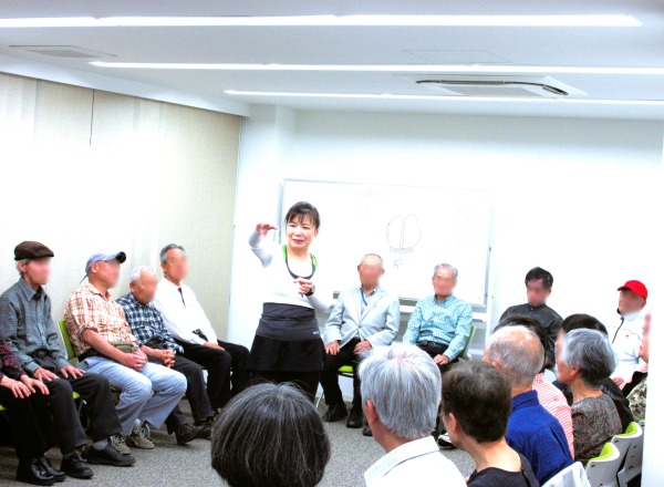 企業のセミナーでストレス管理の重要性を説明している女性講師タニカワ久美子